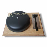 Gong de ring de boxe 25 cm noir mat et son maillet acier rangé sur le socle, vue de trois quarts