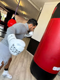 Champion suisse poids lourd avec les gants de sparring Esprit Boxe blancs, travail au sac