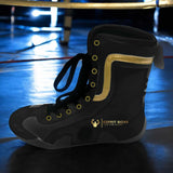 Botte de boxe noir et or posée au bord d'un ring