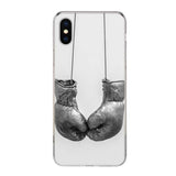 Coque iPhone gants de boxe gris au cuir patiné, suspendus à deux fils fins sur fond blanc