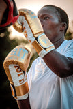 Boxeur à l'entraînement au coucher du soleil avec les gants de sparring Esprit Boxe dorés