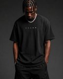 Devant du t-shirt noir coupe oversize, TYSON en petites capitales espacées sur la poitrine