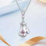 Pendentif gant de boxe femme porté : cœur en cristal rose serti et mot Fight gravé