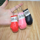 Porte-clés gants de boxe Everlast rouge, rose et noir tenus en main