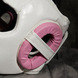Protection d'oreille rose ajourée du casque de boxe femme, maintenue par une sangle blanche