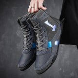 Paire de chaussures de boxe grises tenue par les lacets