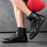 Chaussures de boxe noir et or portées debout, appui avant