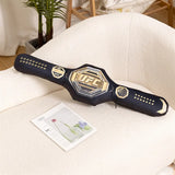 Coussin ceinture UFC posé sur un fauteuil, plaque dorée et sangle cloutée