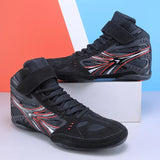 Paire de chaussures de boxe noires et rouges posées sur un bloc
