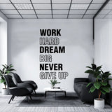 Sticker Work Hard Dream Big Never Give Up posé dans un salon aux murs gris