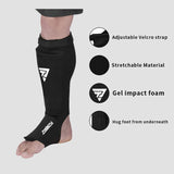 Protège-tibia chaussette noir porté, sangle velcro réglable à la cheville