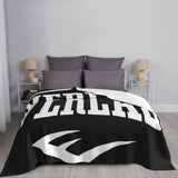 Plaid Everlast déployé sur un lit, logo blanc pleine largeur