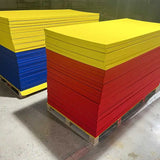Palettes de tatamis paille de riz jaunes, rouges et bleus empilés en entrepôt