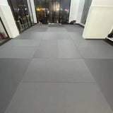 Sol de tatamis vinyle lisse gris posé mur à mur dans une salle vitrée