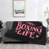 Plaid No Boxing No Life rose drapé sur un canapé gris