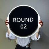 Panneau lumineux round de boxe ROUND 02 tenu à deux mains