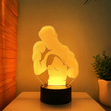 Veilleuse boxeur LED éclairée en jaune sur socle noir
