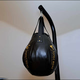 Sac poire à uppercut Esprit Boxe accroché en salle de boxe, ventre bas et pointe haute