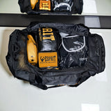Sac de sport boxe 70 L ouvert : gants de boxe, protège-tibias et textile à l'intérieur
