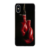 Coque iPhone gants de boxe rouges suspendus par les lacets à un crochet, clair-obscur sur fond noir