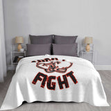 Plaid Born to Fight déployé sur un lit, lettrage rouge et noir