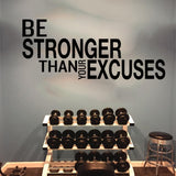 Sticker Be Stronger Than Your Excuses posé au-dessus d'un rack d'haltères