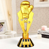 Trophée boxe constitué d'un gant de boxe sur une statue étoilée, finition or