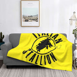 Plaid boxe Italian Stallion jaune drapé sur un canapé gris