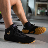 Chaussures de boxe noir et or portées, semelle caramel visible