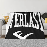 Plaid boxe Everlast noir drapé sur un canapé clair, logo blanc