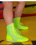 Chaussures de boxe vert fluo portées par un boxeur sur un ring
