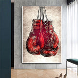 Tableau gants de boxe rouges laces suspendus sur fond creme, accroche dans une entree