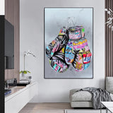 Tableau gants de boxe couverts de graffitis sur fond bleu pale, affiche dans un salon