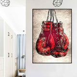 Tableau gants de boxe rouges laces suspendus sur fond creme, vue rapprochee de la toile