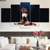 Tableau Mohamed Ali 5 pièces accroché au-dessus d'un canapé blanc